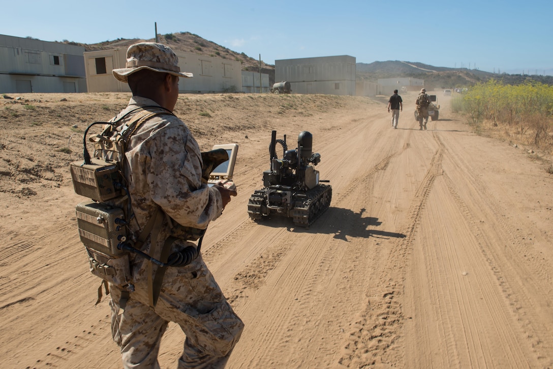 Marine Corps Pfc. Edgar Langle operates a newly developed Modular Advanced Armed Robotic System in a field environment at Marine Corps Base Camp Pendleton, Calif., July 8, 2016.  The Marine Corps Warfighting Laboratory built the system to assist Marines in carrying gear and clearing buildings. Lance Cpl. Julien Rodarte