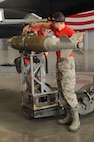 Weapons load crew team members from the 96th Aircraft Maintenance Unit Team Cobra 1, transport a GBU-38 during the second quarter weapons load competition at Barksdale Air Force Base, La., July 8, 2016. AMUs regularly compete against one another to determine which team is most proficient at loading a B-52 Stratofortress with a variety of ordnance. (U.S. Air Force photo/Airman Alexis C. Frost)
