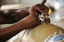 Staff Sgt. Charlie Mathis, 20th Aircraft Maintenance Unit Crew Viper 7 member, inspects and secures munitions during a weapons load competition at Barksdale Air Force Base, La., July 8, 2016. The 20th AMU and the 96th Aircraft Maintenance Unit are inspected during the competition to see which team could inspect, prepare and load weapons onto a B-52 Stratofortress with the least amount of discrepancies. (U.S. Air Force Photo/Airman Alexis C. Frost)