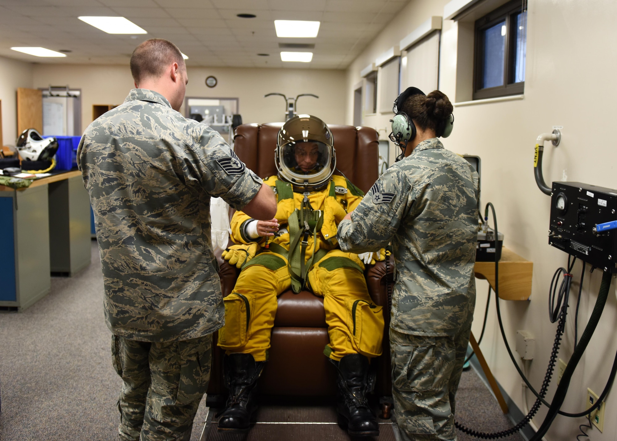 Tech. Sgt. Shawn Rose (left), and Senior Airman Christian Mitchell, 9th Physiological Support Squadron aerospace physiology technicians, assist Lt. Col. Nicole Mann, United States Marine Corps, NASA astronaut, with a full-pressure suit July 7, 2016, at Beale Air Force Base, California. Mann is undergoing Space Flight Readiness Training. (U.S. Air Force photo/ Senior Airman Bobby Cummings)