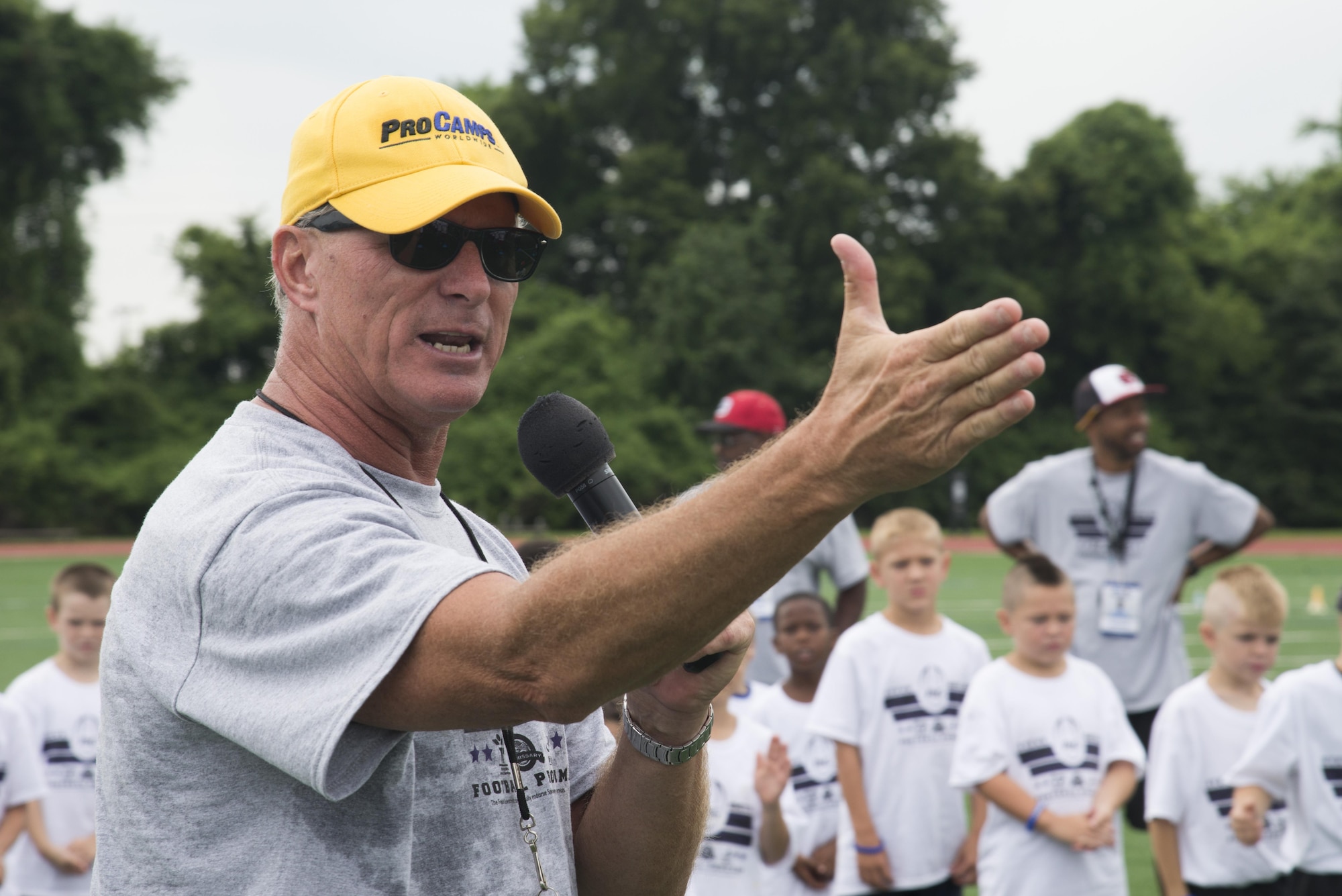 Rod Huber, head football coach at Mount St. Joseph University, instructs children participating in the Steve Smith Pro Camp at Scott Air Force Base, Ill., July 6, 2016. Huber has participated in approximately 20 pro-camps on military bases and has worked with Steve Smith, Baltimore Ravens wide receiver, for 9 years. (U.S. Air Force photo by Airman 1st Class Gwendalyn Smith)