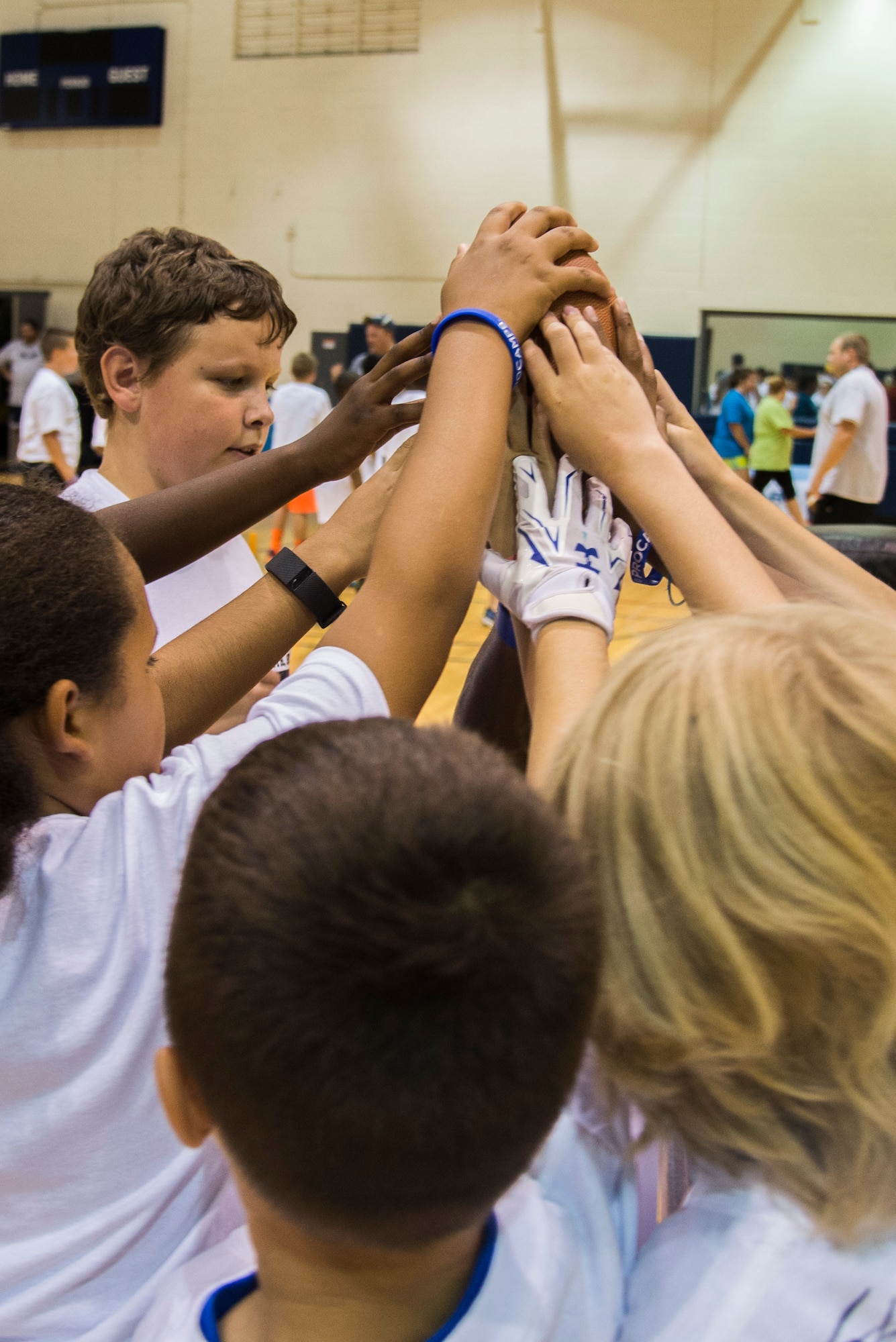 Youth of Scott Air Force Base, Ill. gather around to put hands in during the Steve Smith Pro Camp event July 6, 2016. Steve Smith is a wide receiver for the Baltimore Ravens football team and has participated in 11 Pro Camp events on military bases across the world. The Pro Camp event included offensive, defensive and quarterback drills for the youth of Scott AFB. (U.S. Air Force Photo by Airman Daniel Garcia) 