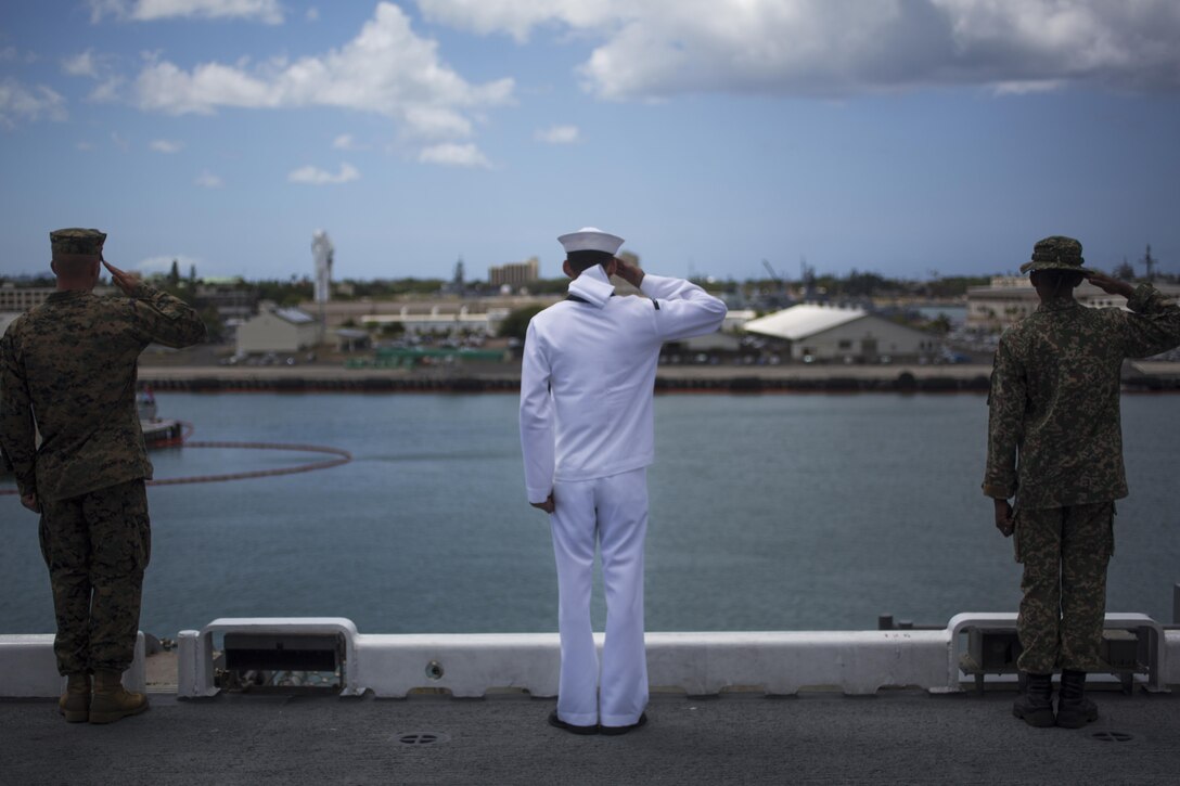 160712-M-PQ336-006
PEARL HARBOR, USS AMERICA (July 12, 2016) — A U.S. Marine, sailor and a Malaysian soldier salute as USS America leaves port July 12, 2016. III Marine Expeditionary Forces will conduct mission rehearsals of landing force integration with an amphibious task force during Rim of the Pacific 2016. Twenty-six nations, 49 ships, six submarines, about 200 aircrafts, and 25,000 personnel are participating in RIMPAC 2016 from June 29 to Aug. 4 in and around the Hawaiian Islands and Southern California. The world’s largest international maritime exercise, RIMPAC provides a unique training opportunity while fostering and sustaining cooperative relationships between participants critical to ensuring the safety of sea lanes and security on the world’s oceans. (U.S. Marine Corps photo by Cpl. Isaac Ibarra)