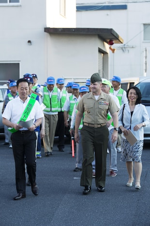 U.S. Marine Corps Col. Robert V. Boucher, commanding officer of Marine Corps Air Station Iwakuni, and the Honorable Yoshihiko Fukuda, mayor of Iwakuni, lead the crowd and local Japanese media down the streets of Iwakuni during the seventh Joint Leadership Walk on July 6, 2016. The last walk took place in December 2015 and continues to be a firm demonstration of the bond and unity between both communities. (U.S. Marine Corps photo by Lance Cpl. Donato Maffin/Released)