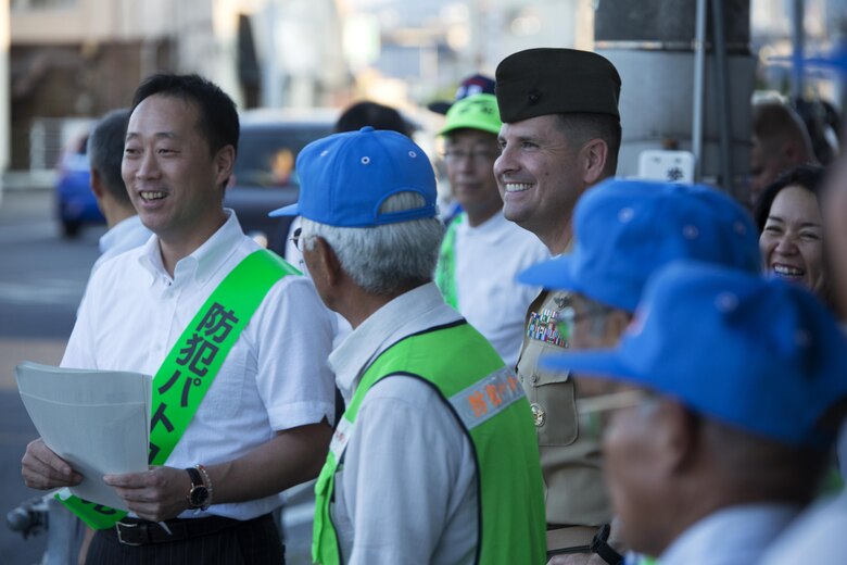 U.S. Marine Corps Col. Robert V. Boucher, commanding officer of Marine Corps Air Station Iwakuni, right, and the Honorable Yoshihiko Fukuda, mayor of Iwakuni, wait to cross an intersection during the seventh Joint Leadership Walk down the streets of Iwakuni on July 6, 2016. The last walk took place in December 2015 and continues to be a firm demonstration of the bond and unity between both communities. (U.S. Marine Corps photo by Lance Cpl. Donato Maffin/Released)