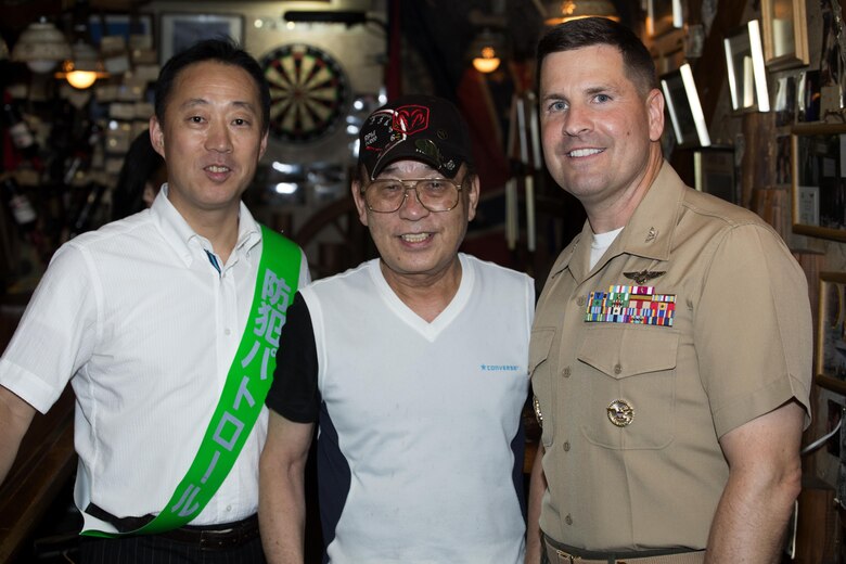 The Honorable Yoshihiko Fukuda, mayor of Iwakuni, Japan, left, and U.S. Marine Corps Col. Robert V. Boucher, commanding officer of Marine Corps Air Station Iwakuni, pose for a photo with Eddie M. Nagamine, a store owner, during the seventh Joint Leadership Walk down the streets of Iwakuni on July 6, 2016. The last walk took place in December 2015 and continues to be a firm demonstration of the bond and unity between both communities. (U.S. Marine Corps photo by Lance Cpl. Donato Maffin/Released)