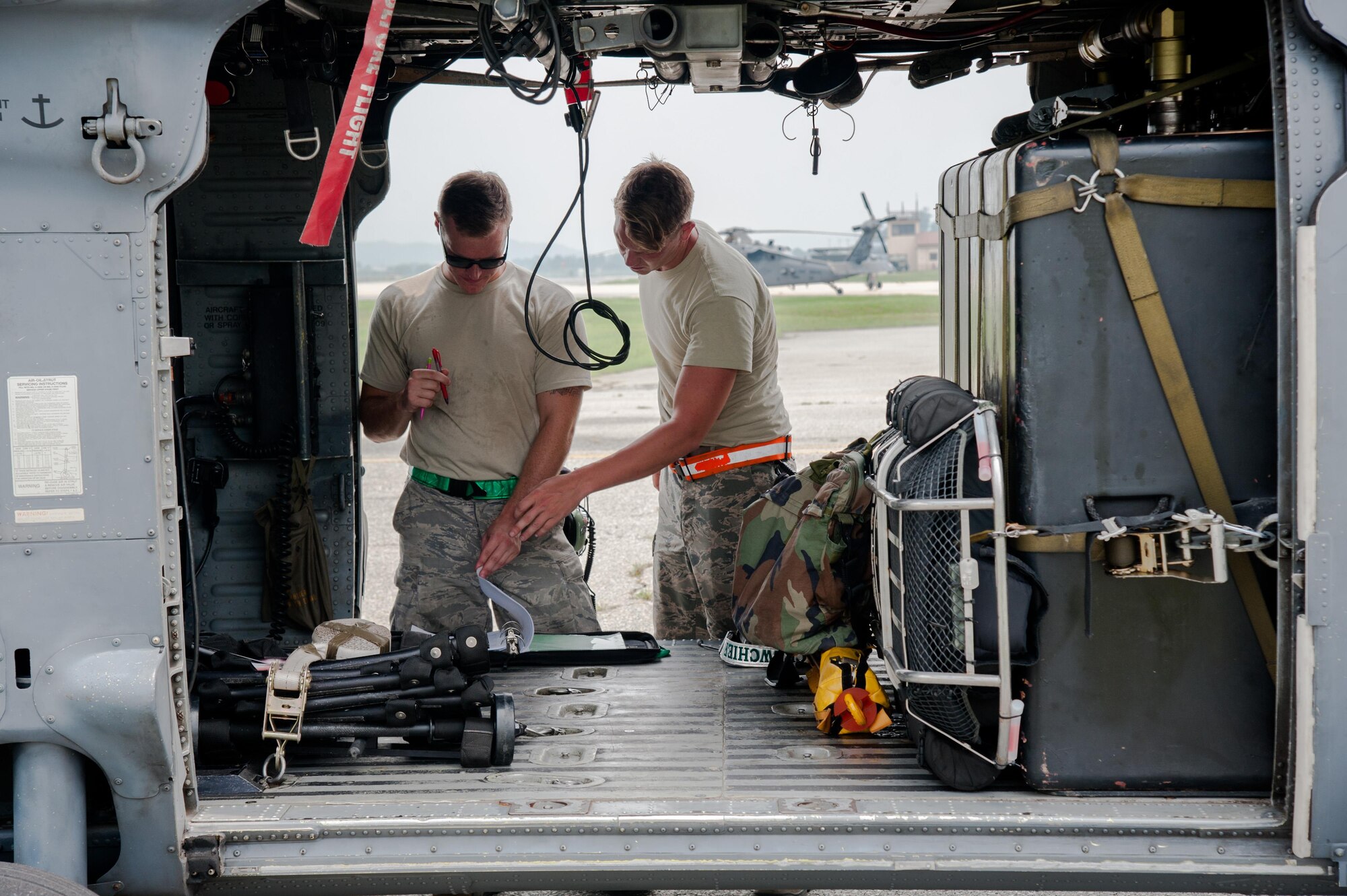 Senior Airman James Turnbull, 33rd Helicopter Maintenance Unit crew chief, and Senior Airman Sheridan McNeil, 33rd HMU aerospace propulsion technician, document post-flight maintenance on an HH-60G Pave Hawk from the 33rd Rescue Squadron before a flight during Exercise Pacific Thunder 16-2 at Osan Air Base, Republic of Korea, July 12, 2016. The 33rd RQS is participating in Pacific Thunder, the largest Pacific combined joint exercise in which U.S. and ROK forces train and test combat search and rescue skills. (U.S. Air Force photo by Staff Sgt. Jonathan Steffen/Released) 