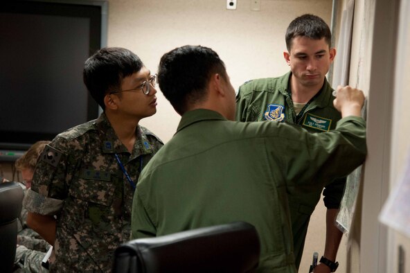 Republic of Korea air force 2nd Lt. Wonseog Chung, Air Force Operations Command combined coordinator translator, ROKAF Capt. Hatae Wook, 123rd Fighter Squadron pilot, and Capt. Zachary Krueger, 25th Fighter Squadron pilot, plan a mission for Exercise Pacific Thunder 16-2 at Osan Air Base, Republic of Korea, July 13, 2016. Pacific Thunder is the largest Pacific combined joint exercise in which U.S. and ROK forces train and test combat search and rescue skills. (U.S. Air Force photo by Staff Sgt. Jonathan Steffen/Released) 