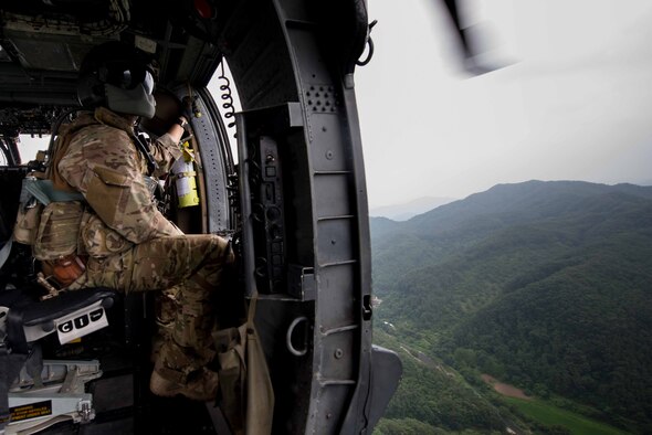 Staff Sgt. Adam Pope, 33rd Rescue Squadron flight engineer, looks out over Republic of Korea countryside during a combat search and rescue scenario for Exercise Pacific Thunder 16-2 at Osan Air Base, Republic of Korea, July 13, 2016. Pacific Thunder is the largest Pacific combat search and rescue exercise designed to test ROK and U.S. forces on their ability rescue a downed pilot behind enemy lines. (U.S. Air Force photo by Staff Sgt. Jonathan Steffen/Released) 