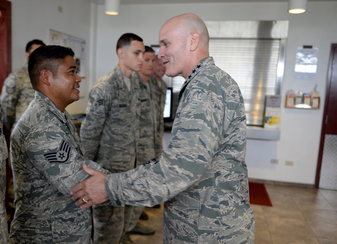Staff Sgt. Danny Cercado, 734th Air Mobility Squadron hydraulics craftsman, left, is coined by Gen. Carlton Everhart, Air Mobility Command commander, during a base visit July, 9, 2016, at Andersen Air Force Base, Guam. During his visit, Everhart expressed his gratitude to the men and women of AMC who provide airlift, aerial refueling, and special air mission and aeromedical evacuation capabilities. (U.S. Air Force photo by Airman 1st Class Alexa Ann Henderson/Released)
