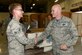 Airman 1st Class Dylan Cruson, 734th Air Mobility Squadron air transportation specialist, left, is coined by Gen. Carlton Everhart, Air Mobility Command commander, during a base visit July 9, 2016, at Andersen Air Force Base, Guam. AMC's mission is to provide rapid, global mobility and sustainment for America's armed forces.
