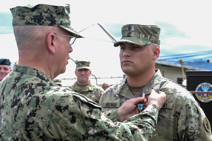 U.S. Army Spc. Tyler Holman, a combat medic assigned to the 1st Battalion, 228th Aviation Regiment, receives the Joint Service Commendation Medal from U.S. Navy Adm. Kurt Tidd, the commander of U.S. Southern Command, at Soto Cano Air Base, Honduras, July 7, 2016. Holman’s rapid response to administer CPR to an unresponsive Honduran teen while on a trip to Roatán, Honduras, are credited with saving her life. (U.S. Air Force photo by Staff Sgt. Siuta B. Ika)