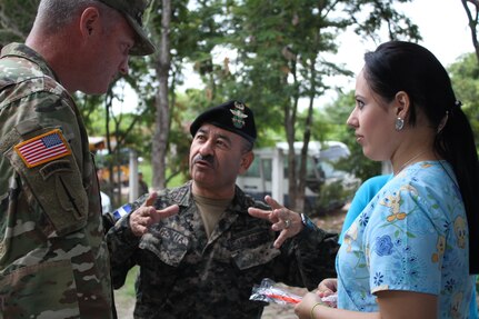 Comayagua, Honduras - U.S. Army Col. Brian Hughes, commander of Joint Task Force-Bravo (left), is briefed on the process used in the Military Partnership Engagement dental services area by Honduran Army Col. Julio Cesar Urquia (center), Director of the Experimental Center of Agricultural Development and Ecological Conservation (CEDACE), and a Honduran dentist (right), during an MPE between JTF-Bravo and CEDACE in San Sebastian, Comayagua, Honduras, July 9, 2016. MPEs provide an opportunity to engage with the community while supporting the Honduran military efforts in providing care for the local population. (U.S. Army photo by Maria Pinel)