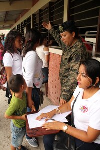 Comayagua, Honduras – A Honduran Army service member from the Experimental Center of Agricultural Development and Ecological Conservation (CEDACE), guides a family to a clinic to receive free medical attention from U.S. Service members and Honduran Ministry of Health representatives during a Military Partnership Engagement between JTF-Bravo and CEDACE in San Sebastian, Comayagua, Honduras, July 9, 2016.  MPEs serve as a great way to build partner nation capacity while providing an opportunity for soldiers to train and engage with the local population. (U.S. Army photo by Maria Pinel)