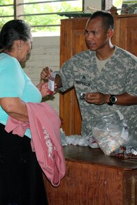 Comayagua, Honduras – U.S. Army Sergeant Jason Nisperos, Joint Task Force-Bravo preventive medicine NCO, hands multivitamins and deworming medication to a Honduran woman during a Military Partnership Engagement between JTF-Bravo and the Experimental Center of Agricultural Development and Ecological Conservation (CEDACE) in San Sebastian, Comayagua, Honduras, July 9, 2016. JTF-Bravo participated on the mission at the request of the Military Commander of CEDACE.  (U.S. Army photo by Maria Pinel)