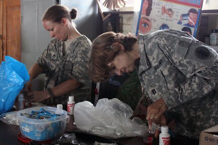 Comayagua, Honduras – U.S. Army Staff Sgt. Lisa Kent and U.S. Army Capt. Katherine Matteson, prepare deworming medication provided for children after receiving an initial health class, during a during a Military Partnership Engagement between JTF-Bravo and the Experimental Center of Agricultural Development and Ecological Conservation (CEDACE) in San Sebastian, Comayagua, Honduras, July 9, 2016. Patients received a health class provided by a representative from the National University of Agriculture, who explained prevention of viruses such as dengue, Zika and chikungunya, followed by JTF-Bravo service members who briefed on hygiene and water sanitation.  (U.S. Army photo by Maria Pinel)