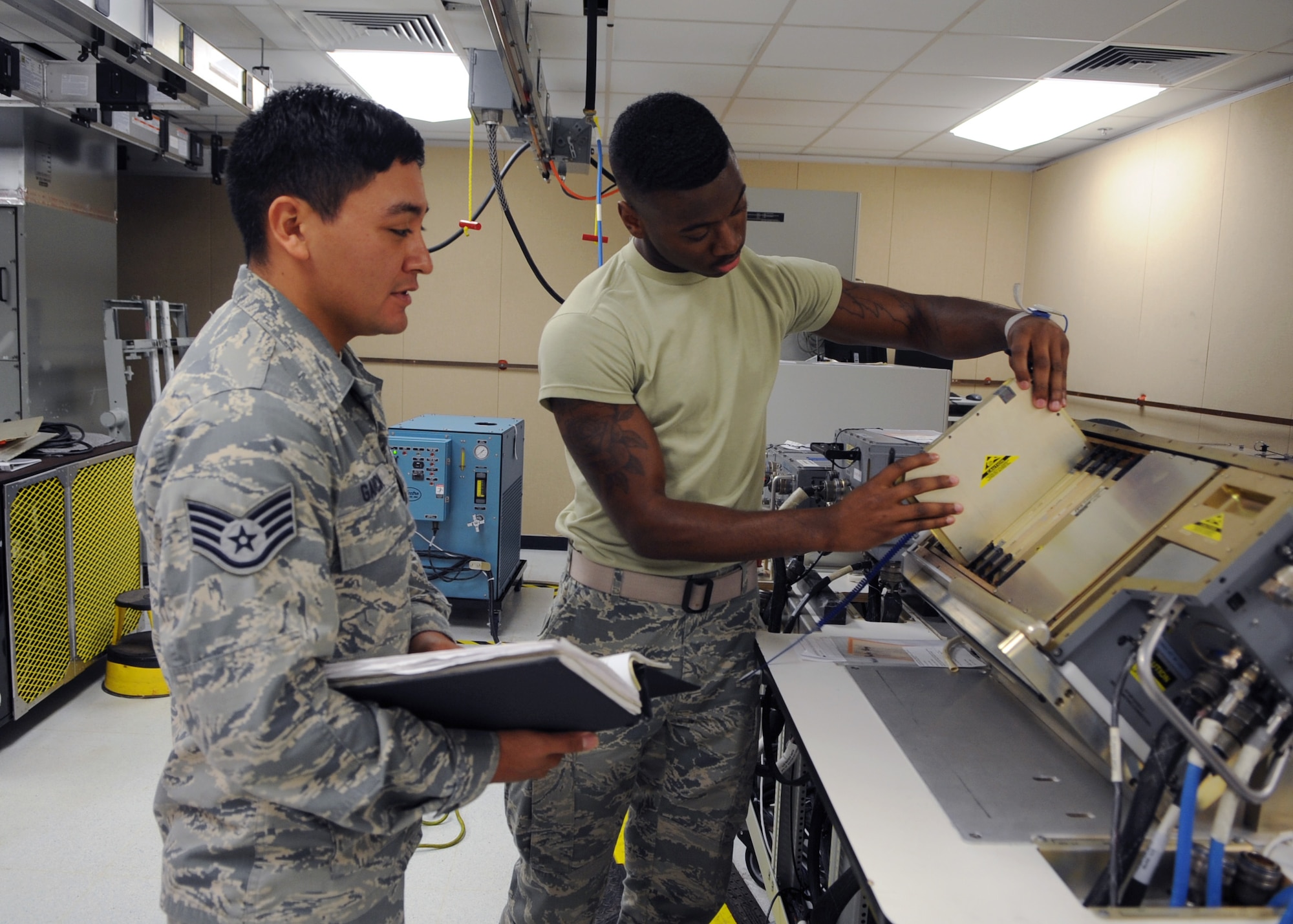 U.S. Air Force Staff Sgt. Jose Garcia, left, 7th Component Maintenance Squadron avionics craftsman, assists as Airman 1st Class Elijah Morris-Knight, 7th CMS avionics journeyman, removes a shop replaceable unit June 21, 2016, at Dyess Air Force Base, Texas. This process is necessary to assess any damage to the electrical mating pins for any possible failures. The electrical mating pins send or generate data to the offensive avionics systems on the B-1B Lancer. (U.S. Air Force photo by Senior Airman Kedesha Pennant/Released)
