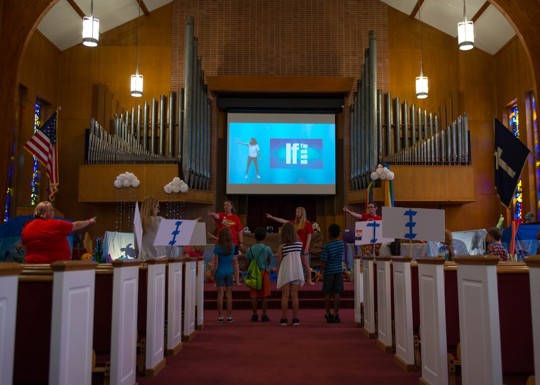Children and counselors sing and dance in the Regimental Memorial Chapel during Vacation Bible School at Fort Eustis, Va., July 12, 2016. Each morning of the week-long school began with a musical performance that has a message pertaining to the week’s various lessons. (U.S. Air Force photo by Staff J.D. Strong II)
