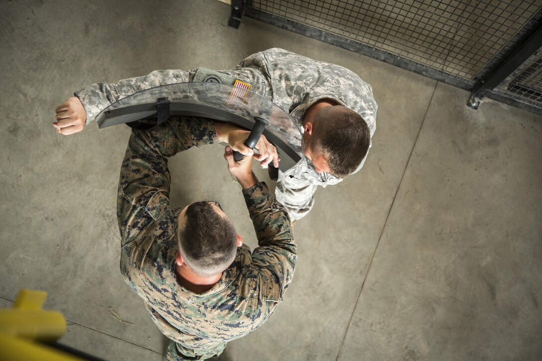 Marine Corps Gunnery Sgt. Timothy Hanson demonstrates detainee extraction procedures on Army Sgt. Jacob Stone during Warrior Exercise at Fort McCoy, Wis., July 12, 2016. The exercise helps keep soldiers across the United States ready to deploy. Stone is assigned to the 79th Military Police Company. Army photo by Spc. John Russell