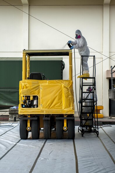 U.S. Air Force Senior Airman Bryan Orozco, 18th Logistics Readiness Squadron mission generation equipment vehicle maintenance journeyman, and Tech. Sgt. Justin Petty, 18th LRS allied trades non-commissioned officer in charge, apply undercoat to a Volvo PT-125 roller as part of an anti-corrosion program July 7, 2016, at Kadena Air Base, Japan. Petty developed the program to reduce humidity and water damage to the airfield damage repair fleet, valued at approximately $15 million, which will save the Air Force $2-3 million in repairs over the life-span of the vehicles and assets. (U.S. Air Force photo by Senior Airman Peter Reft) (This image was enhanced using multiple filters and dodging and burning techniques)