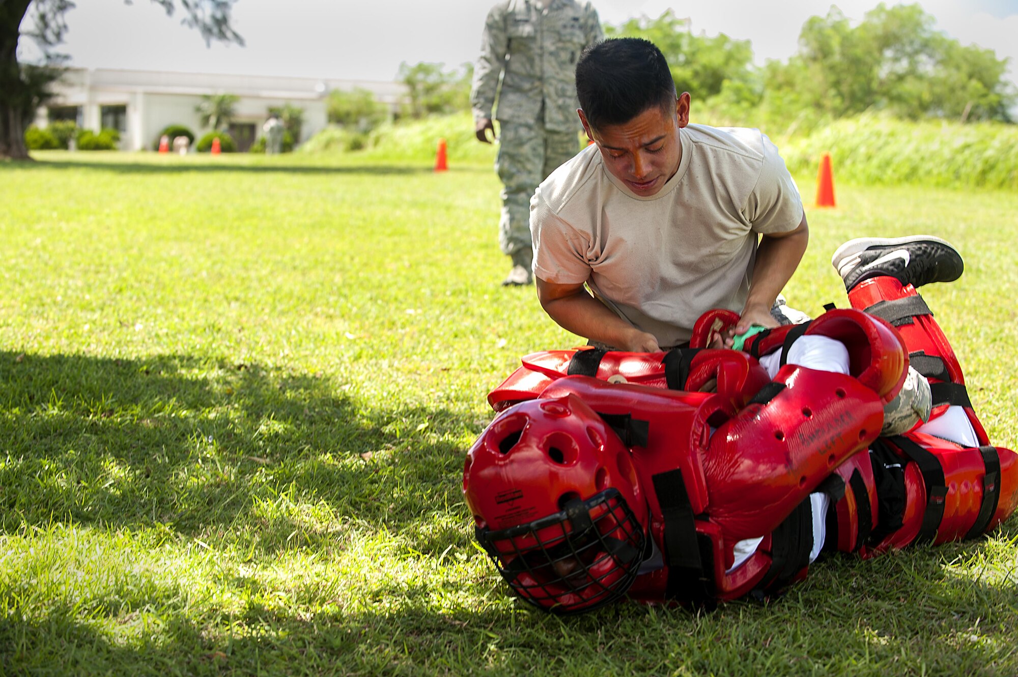 U.S. Air Force Airman Joshua Lenaire, 18th Security Forces Squadron response force member, subdues an attacker in a red-man suit after being sprayed with OC spray during training July 13, 2016, at Kadena Air Base, Japan. Security forces members must be able to perform their mission, even if they are under extreme pain and impaired vision. (U.S. Air Force photo by Airman 1st Class Corey M. Pettis)