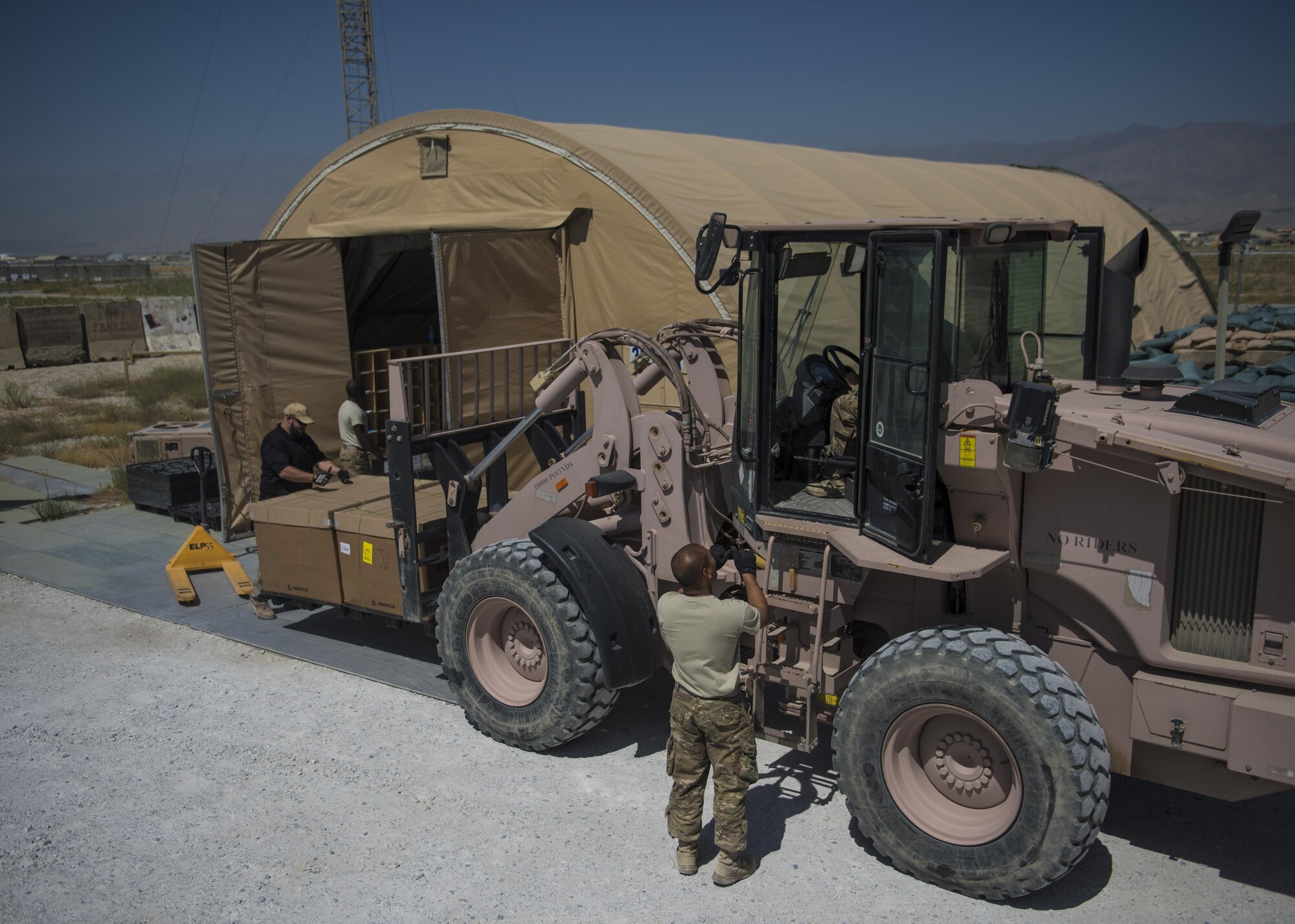 Mr. Shaun Cole, Airman 1st Class Hayden Kidder, and Staff Sgt. Tony Tran, 455th Expeditionary Communications Squadron knowledge management, move packages to the mail tent, July 13, 2016, Bagram Airfield, Afghanistan. Members of the 455th ECS knowledge management flight help with the postal additional duty. The task includes receiving, organizing, and distributing mail to the organizations throughout the base. (U.S. Air Force photo by Senior Airman Justyn M. Freeman)