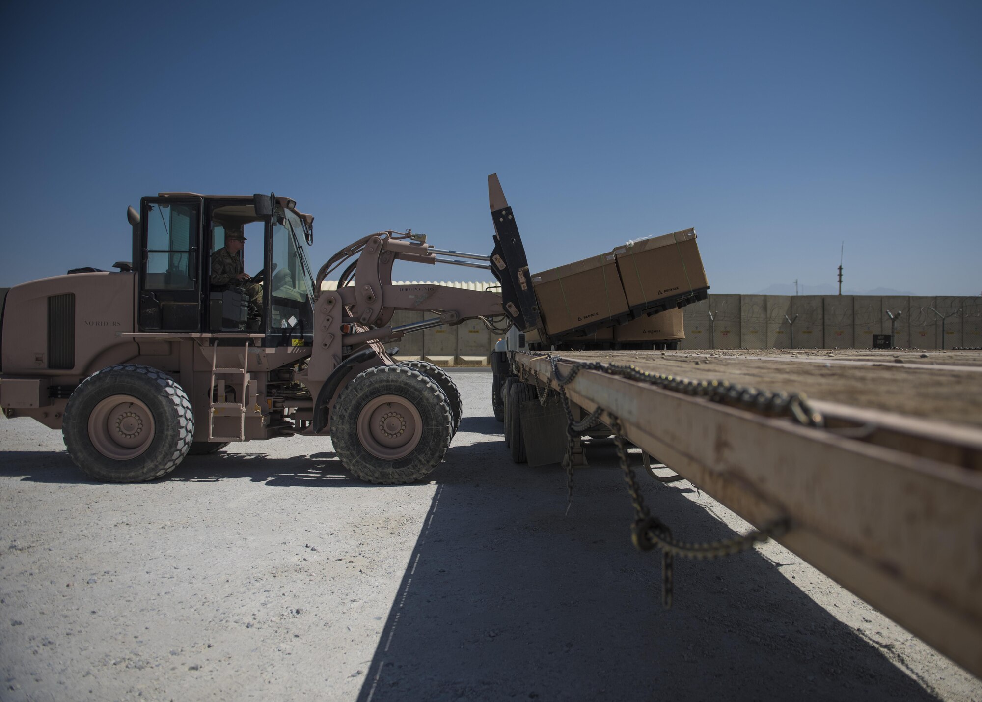 Airman 1st Class Hayden Kidder, 455th Expeditionary Communications Squadron knowledge management craftsman, uses a 10k forklift to move mail tri-walls off a flatbed trailer, July 13, 2016, Bagram Airfield, Afghanistan. Members of the 455th ECS coordinate with the Army Logistics Readiness Squadron to deliver mail tri-walls once they have exceeded the 455th ECS mail truck’s load capacity. (U.S. Air Force photo by Senior Airman Justyn M. Freeman)