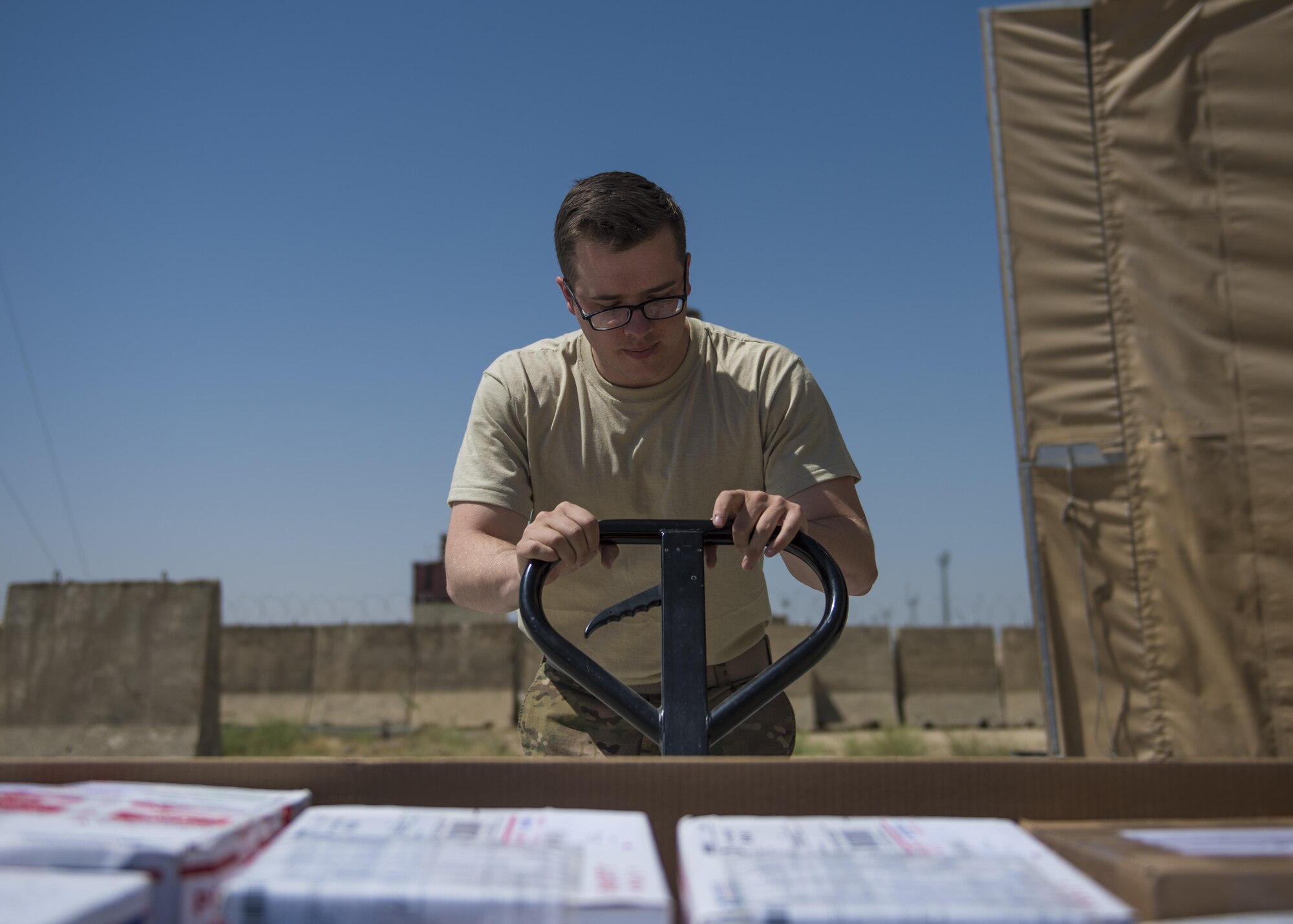 Senior Airman Christopher Collins, 455th Expeditionary Communications Squadron knowledge management craftsman, lifts a mail tri-wall, July 13, 2016, Bagram Airfield, Afghanistan. Mail tri-walls contain packages and letters that have been shipped from the United States or abroad. (U.S. Air Force photo by Senior Airman Justyn M. Freeman)