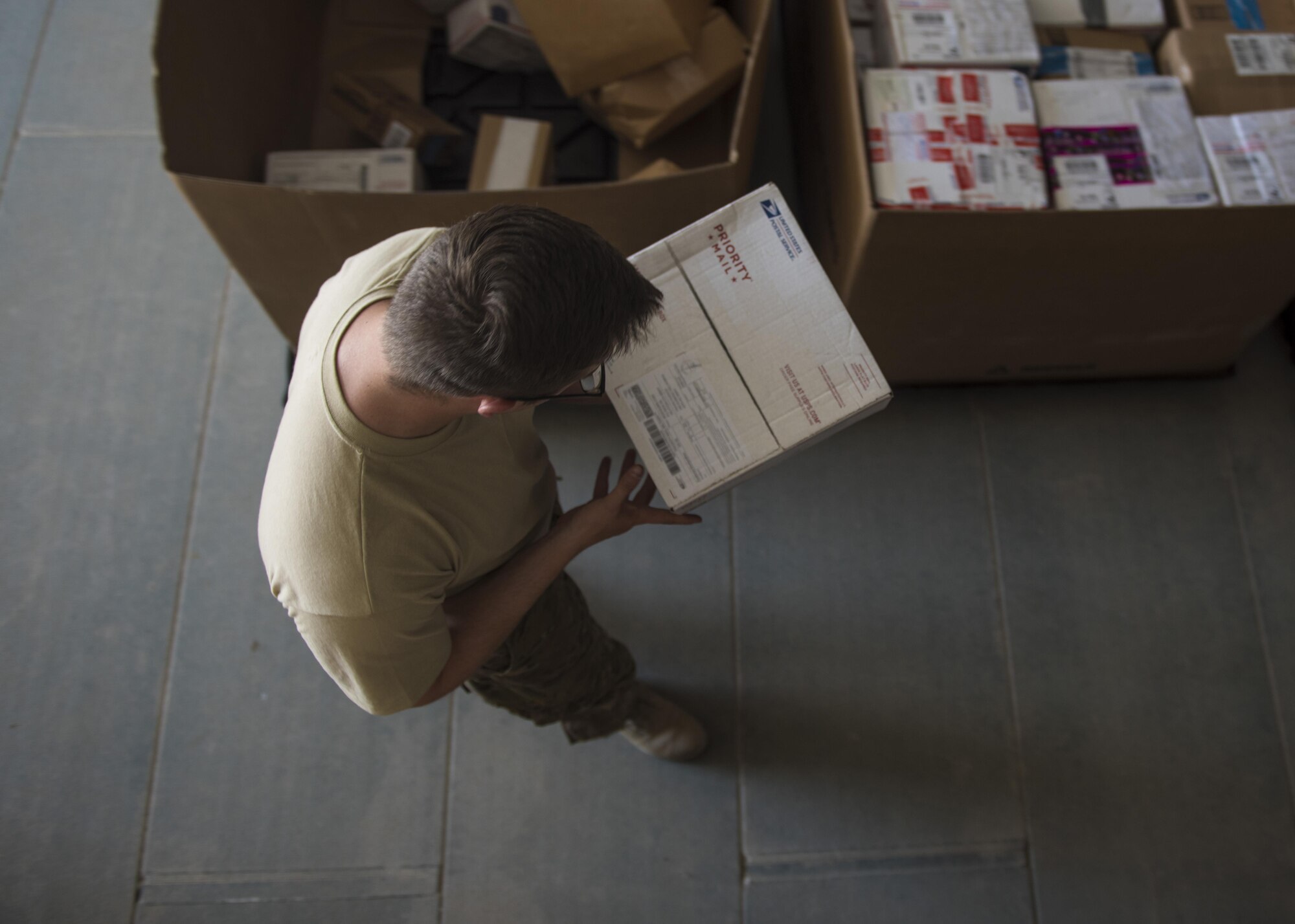 Senior Airman Christopher Collins, 455th Expeditionary Communications Squadron knowledge management craftsman, looks at a shipping address, July 13, 2016, Bagram Airfield, Afghanistan. Members of the 455th ECS knowledge management flight help with the postal additional duty. The task includes receiving, organizing, and distributing mail to the organizations throughout the base. (U.S. Air Force photo by Senior Airman Justyn M. Freeman)