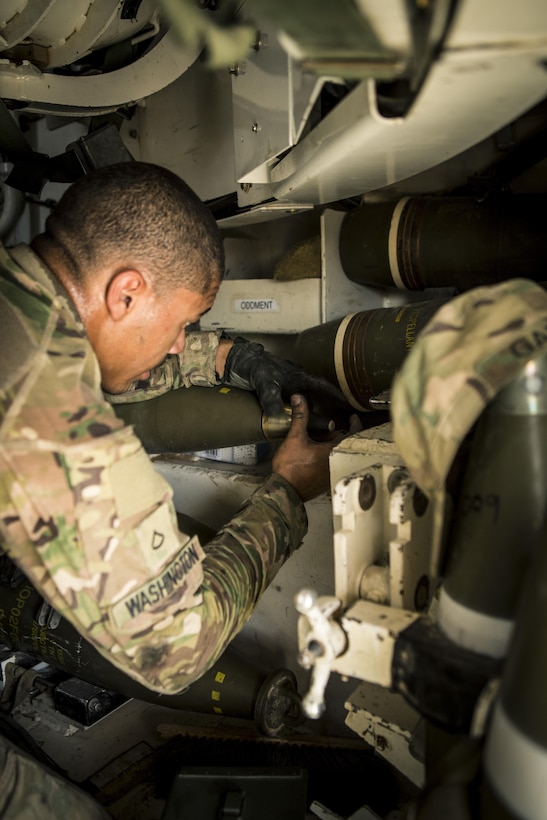 Army Pfc. Chase Washington prepares rounds for a fire mission at Al-Taqaddum Air Base, Iraq, June 27, 2016, to support Operation Inherent Resolve. Washington is an M109A6 Paladin howitzer cannoneer with Battery C, 4th Battalion, 1st Field Artillery Regiment, 1st Armored Division, Task Force Al Taqaddum. Marine Corps photo by Sgt. Donald Holbert