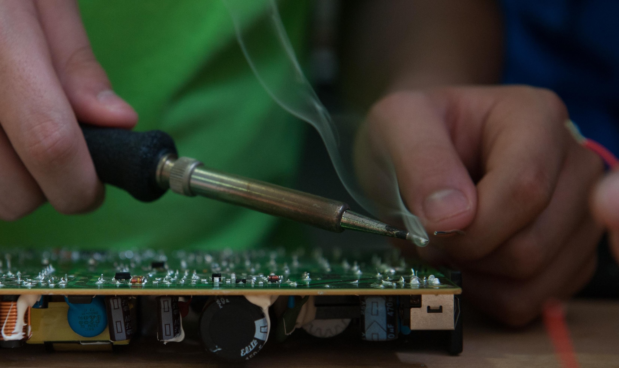 A child solders a wire into a desktop motherboard as he participates in a Science, Technology, Engineering and Mathematics youth camp July 12, 2016, at Ramstein Air Base, Germany. The camp engaged children throughout the week with brain-stimulating activities such as completing construction projects, coding computer programs and experimenting with drones.