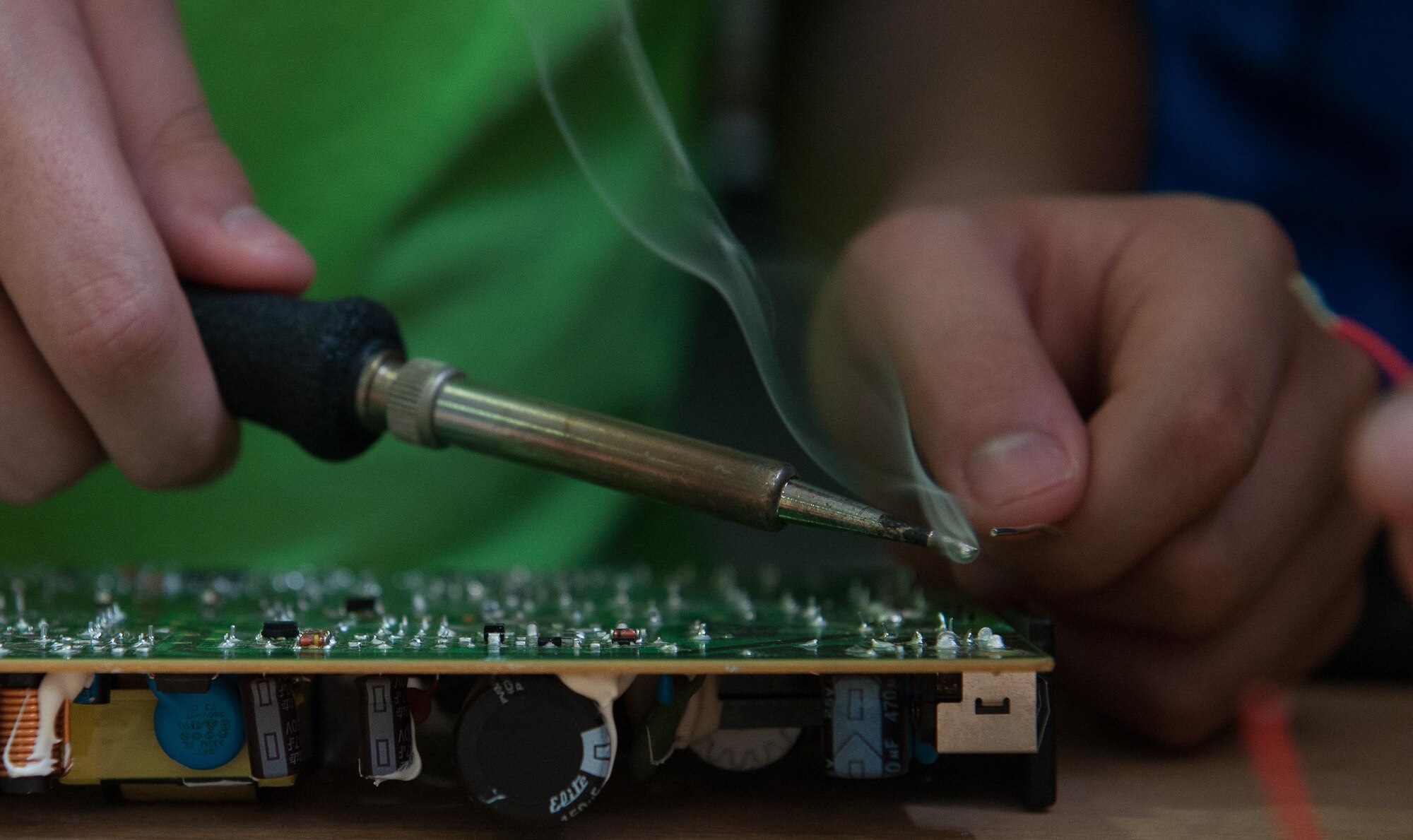 A child solders a wire into a desktop motherboard as he participates in a Science, Technology, Engineering and Mathematics youth camp July 12, 2016, at Ramstein Air Base, Germany. The camp engaged children throughout the week with brain-stimulating activities such as completing construction projects, coding computer programs and experimenting with drones.