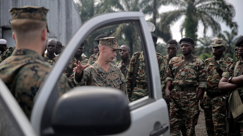 Cpl. John Lambert, a rifleman with Special Purpose Marine Air-Ground Task Force Crisis Response-Africa, shows Cameroonian soldiers with Forces Fusiliers Marins et Palmeurs de Combat how to conduct a vehicle search in Limbé, Cameroon, June 30, 2016.  Marines share tactics, techniques and skills with the FORFUMAPCO soldiers to combat the illicit trafficking in Cameroon. 