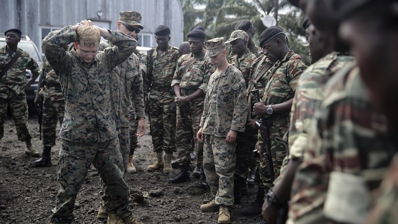Lance Cpl. Christopher Parsons, and Lance Cpl. Dustin Kitts, riflemen with Special Purpose Marine Air-Ground Task Force Crisis Response-Africa, shows Cameroonian soldiers with Forces Fusiliers Marins et Palmeurs de Combat how to conduct personnel searches in Limbé, Cameroon, June 30, 2016.  Marines share tactics, techniques and skills with the FORFUMAPCO soldiers to combat the illicit trafficking in Cameroon. 