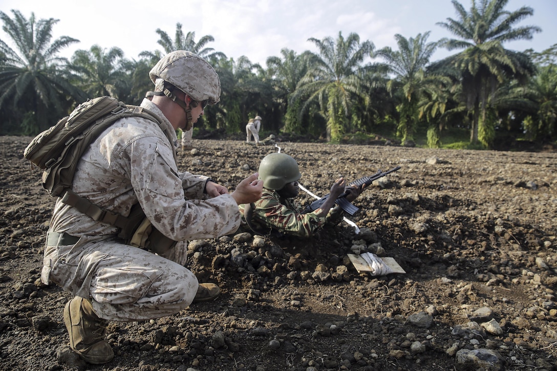 Cpl. Jeremy Osteen, a squad leader with Special Purpose Marine Air-Ground Task Force Crisis Response-Africa, shows a Cameroonian soldier with Forces Fusiliers Marins et Palmeurs de Combat an immediate action drill for his weapon while on the range in Limbé, Cameroon, July 1, 2016.  Marines share tactics, techniques and skills with the FORFUMAPCO soldiers to combat the illicit trafficking in Cameroon.  