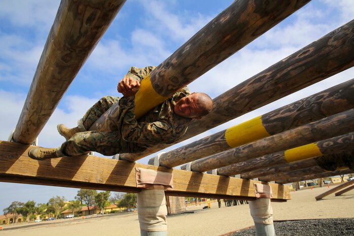 A recruit from Charlie Company, 1st Recruit Training Battalion, navigates through an obstacle during Confidence Course I at Marine Corps Recruit Depot San Diego, July 11. Recruits must use their strength to navigate over and under the logs while trying to maintain a low profile. Annually, more than 17,000 males recruited from the Western Recruiting Region are trained at MCRD San Diego. Charlie Company is scheduled to graduate Sept. 16.