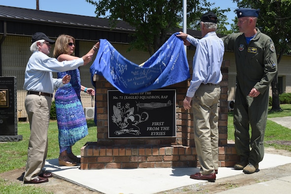 Jim Rowley (far left), Felicia Hutto (center left), and Howard Rowley (center right), family members of William Dunn, British Royal Air Force Squadron 71 member and first American ace of World War II, along with Lt. Col. Nathan Mead (right), 334th Fighter Squadron commander, unveil a memorial dedicated to the British Royal Air Force Squadron 71 members, July 8, 2016, at Seymour Johnson Air Force Base, North Carolina. The 334th FS traces its roots to the RAF Squadron 71 during World War II. (U.S. Air Force photo by Airman 1st Class Ashley Williamson)
