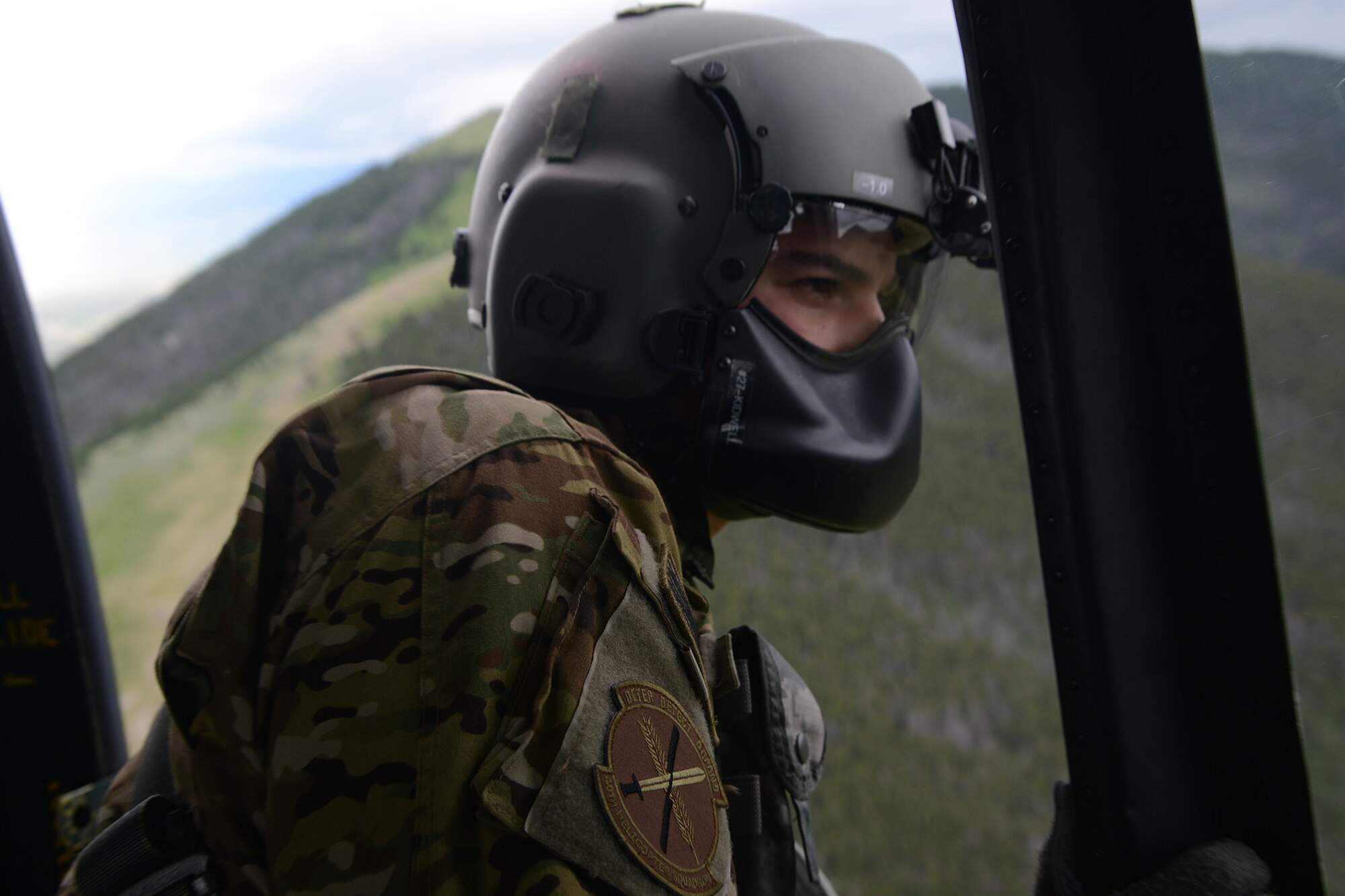Tech. Sgt. Travis Kidwell, 40th Helicopter Squadron UH-1N Iriquois flight engineer, calls approach to the pilots as they descend into the landing zone July 6, 2016, near Malmstrom Air Force Base, Mont. Flight engineers guide the pilots using a countdown while looking outside to ensure the main and tail rotors are clear of any obstacles. (U.S. Air Force photo/Staff Sgt. Delia Marchick)