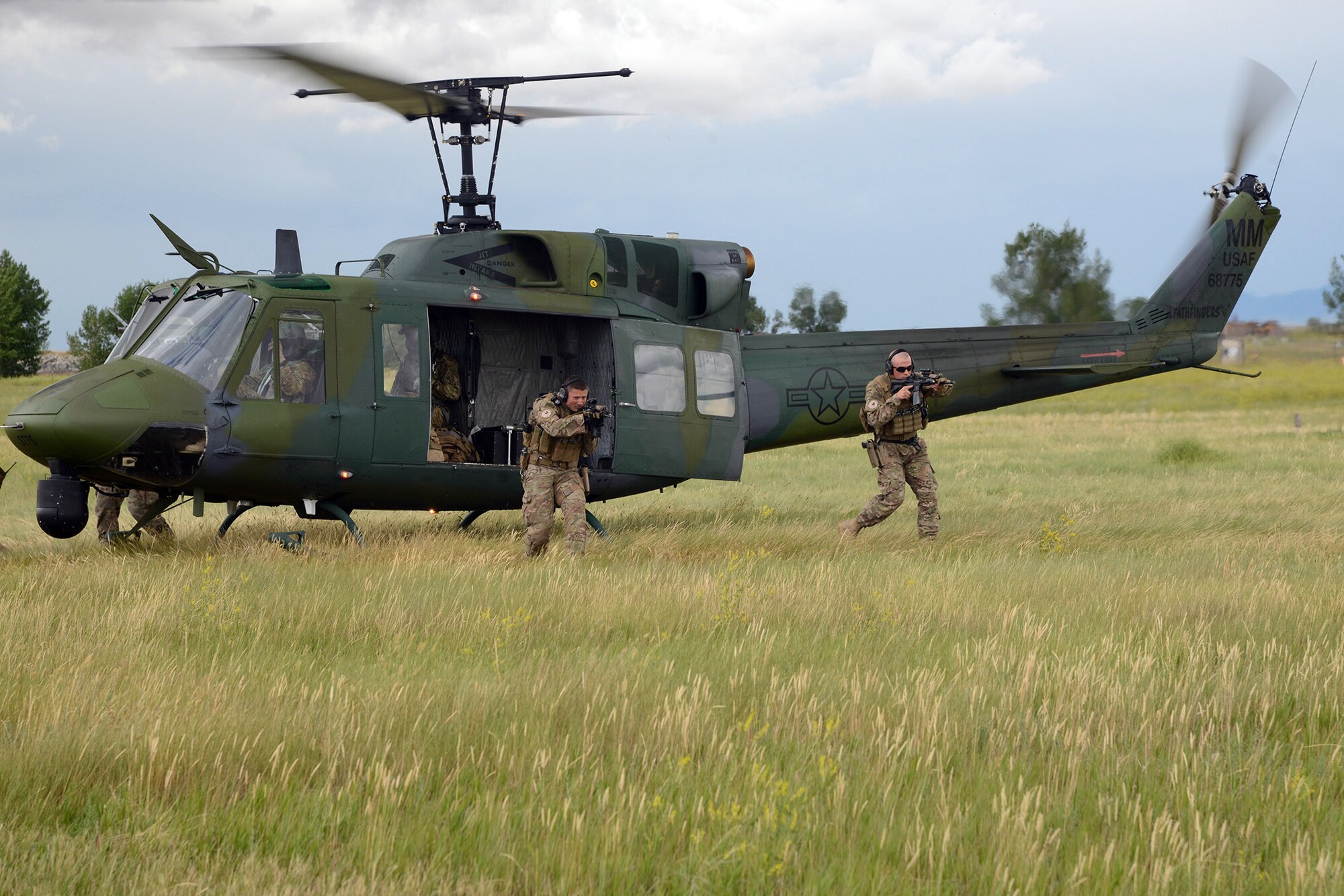 Tactical Response Force Airmen from the 741st Missile Security Forces Squadron practice a quick departure from a UH-1N Iriquois July 6, 2016, at Malmstrom Air Force Base, Mont. The 40th Helicopter Squadron aircrew and the TRF Airmen conduct day and night infiltration and exfiltration training. (U.S. Air Force photo/Staff Sgt. Delia Marchick)