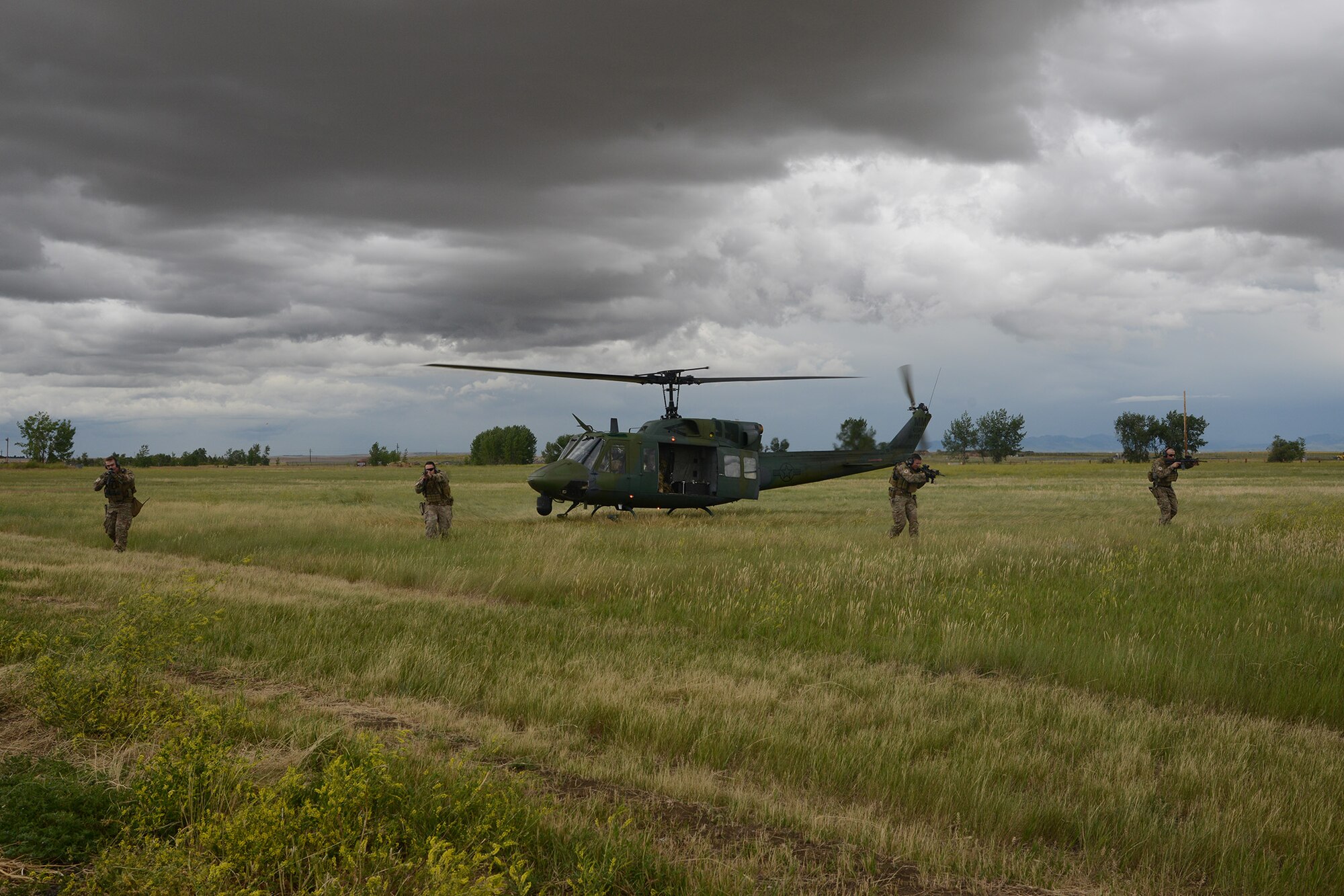 Tactical Response Force Airmen from the 741st Missile Security Forces Squadron line up outside a UH-1N Iriquois to provide ground security at a mock launch facility July 6, 2016, at Malmstrom Air Force Base, Mont. TRF Airmen must pass a rigorous tryout process to make the elite security team. (U.S. Air Force photo/Staff Sgt. Delia Marchick)