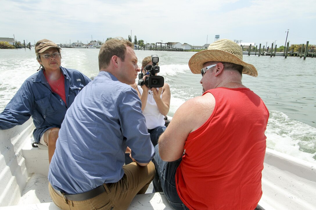 Drew Wilder, (left) a reporter with Richmond based NBC-12 performs an on-camera interview with David Schulte, a Norfolk District, oceanographer about the current situation at Tangier Island, Virginia, July 12, 2016. The Norfolk District, U.S. Army Corps of Engineers is attempting to assist the tiny island in the Chesapeake Bay, which is eroding away due to sea-level rise, erosion and subsidence.   