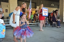 Andrea Carnahan, wife of Staff Sgt. Sean Carnahan, shows her daughter the bus her father is in during Operation Homecoming at Hurlburt Field, Fla., July 7, 2016. Carnahan’s husband spent five months deployed overseas. (U.S. Air Force photo by Airman Dennis Spain)
