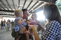 Capt. John Haley, an electronic warfare officer with the 15th Special Operations Squadron, holds his children for the first time in five months at Hurlburt Field, Fla., July 7, 2016. Operation Homecoming is a program designed to welcome Airmen home after they return from a deployment. (U.S. Air Force photo by Airman Dennis Spain)
