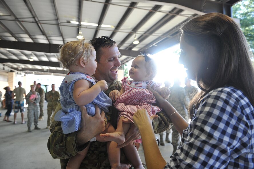 Capt. John Haley, an electronic warfare officer with the 15th Special Operations Squadron, holds his children for the first time in five months at Hurlburt Field, Fla., July 7, 2016. Operation Homecoming is a program designed to welcome Airmen home after they return from a deployment. (U.S. Air Force photo by Airman Dennis Spain)
