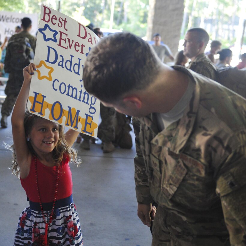 A child raises a poster to celebrate her father’s return from deployment during Operation Homecoming at Hurlburt Field, Fla., July 7, 2016. The returning Airmen were welcomed home by family, friends and coworkers. (U.S. Air Force photo by Airman Dennis Spain)