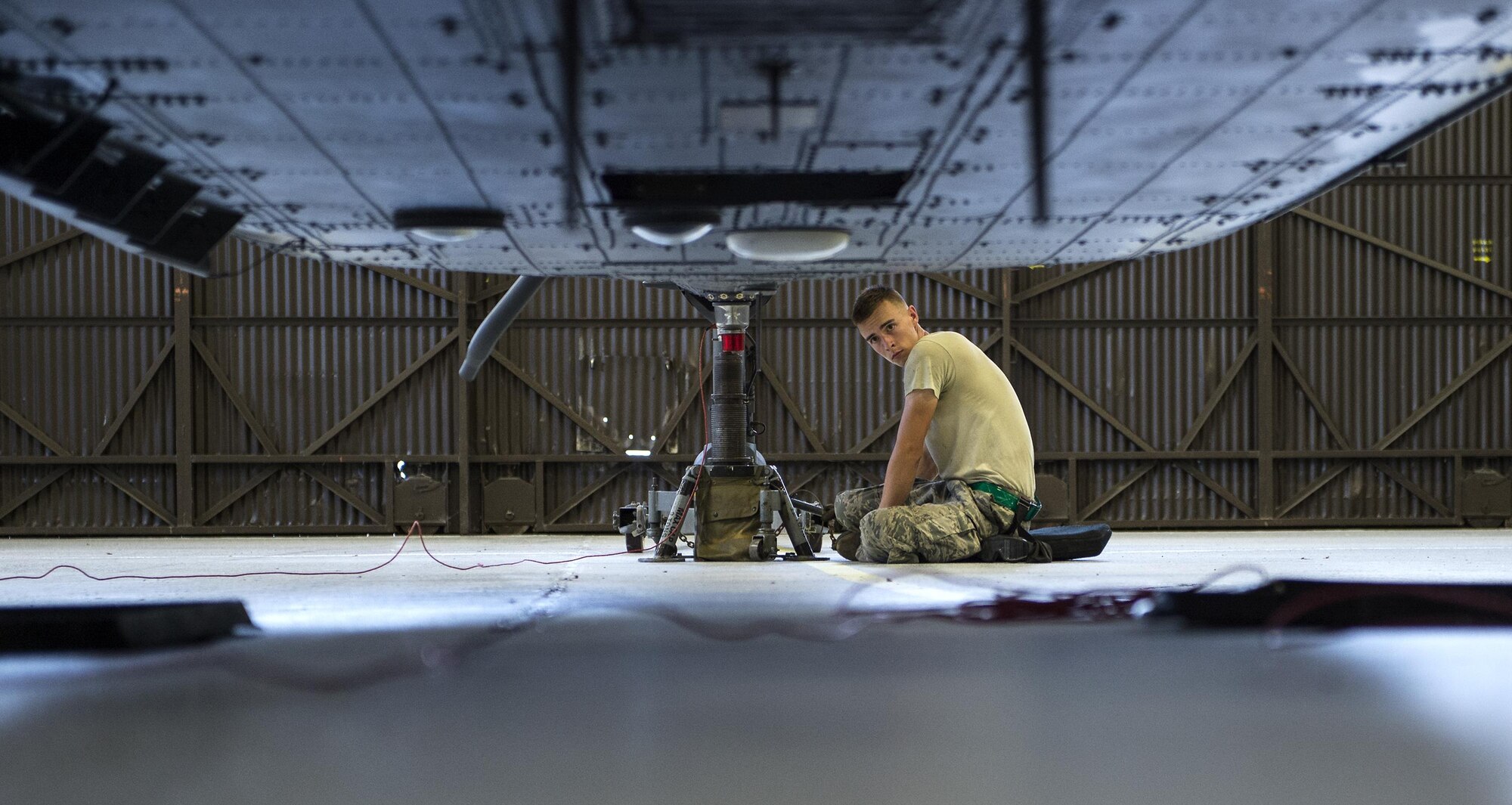 U.S. Air Force Senior Airman Devin Cenzi, 41st Helicopter Maintenance Unit crew chief, waits for instructions, July 7, 2016, at Moody Air Force Base, Ga. A quality assurance inspector leads a team of maintainers as they lower and raise jack stands, to ensure everyone is on the same step and remains safe throughout the process. (U.S. Air Force photo by Airman 1st Class Janiqua P. Robinson)