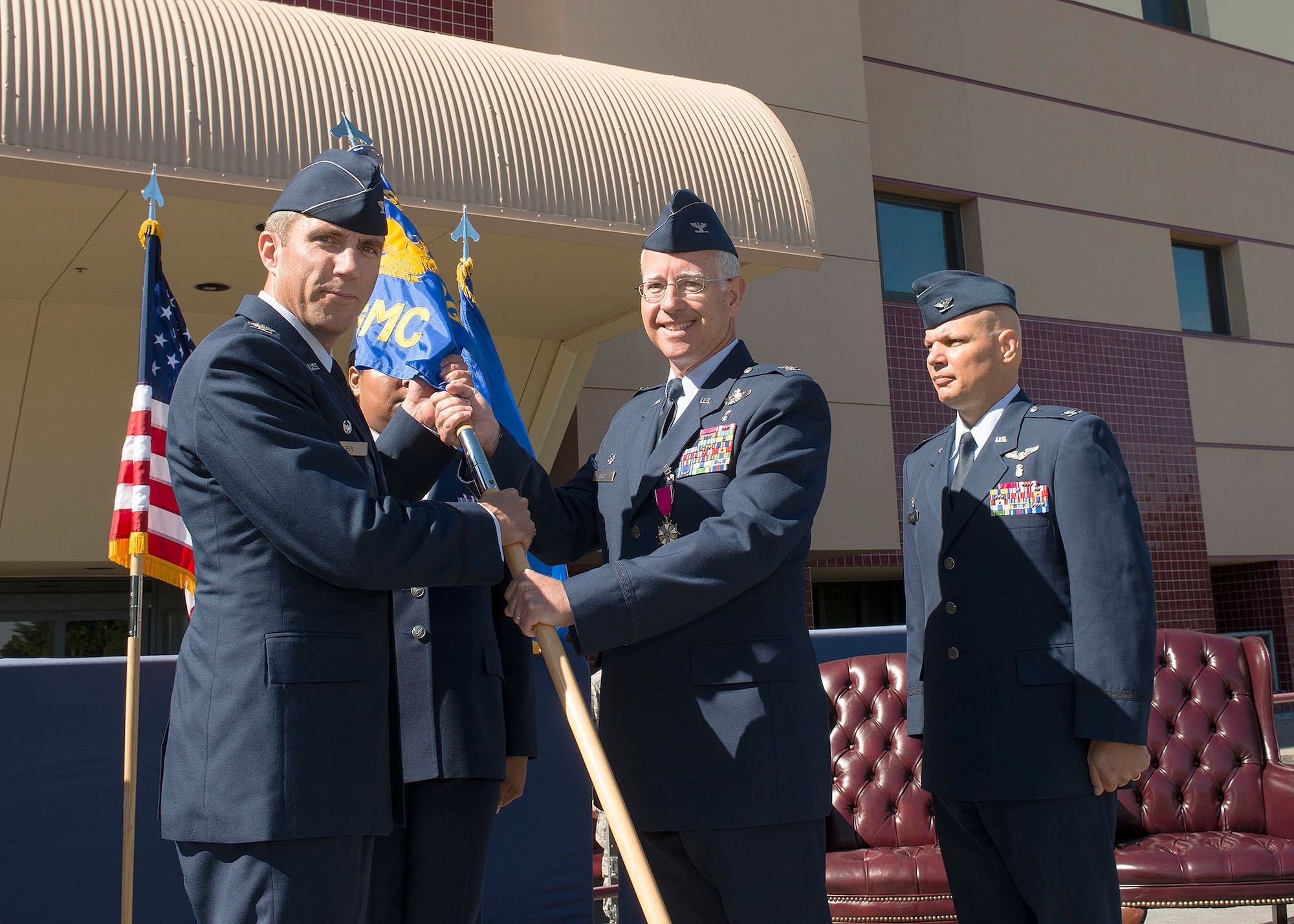 Col. (Dr.) Rawson Wood, center, 60th Medical Group outgoing commander, relinquishes command of the group during a change-of-command at Travis Air Force Base, Calif., July 8, 2016. The 60th Medical Group provides comprehensive community and referral health care, readiness, education, research, teleradiology services, aero medical staging and the DOD/VA joint venture. The group also deploys medical personnel and equipment in support of homeland defense and military contingency operations worldwide. (U.S. Air Force photo by T.C. Perkins Jr.)