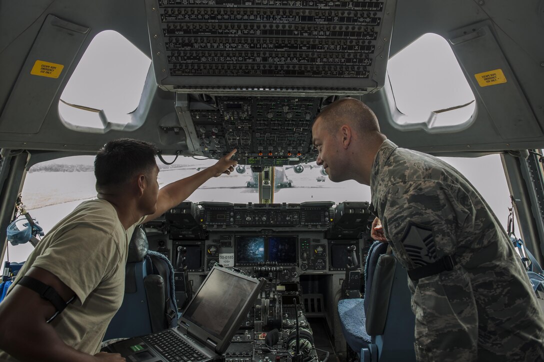 U.S. Air Force Staff Sgt. Arsonio Arthur, 733rd Air Mobility Squadron instrument flight controls systems craftsman, monitors the power of a C-17 Globemaster during a cargo load as Master Sgt. Daniel Hegar, 733rd AMS quality assurance office superintendent, supervises July 6, 2016, at Kadena Air Base, Japan. The 733rd AMS QA office monitors maintenance on the C-17 and the C-5 Galaxy to ensure safe transportation of cargo and troops. (U.S. Air Force photo by Airman 1st Class Lynette M. Rolen)