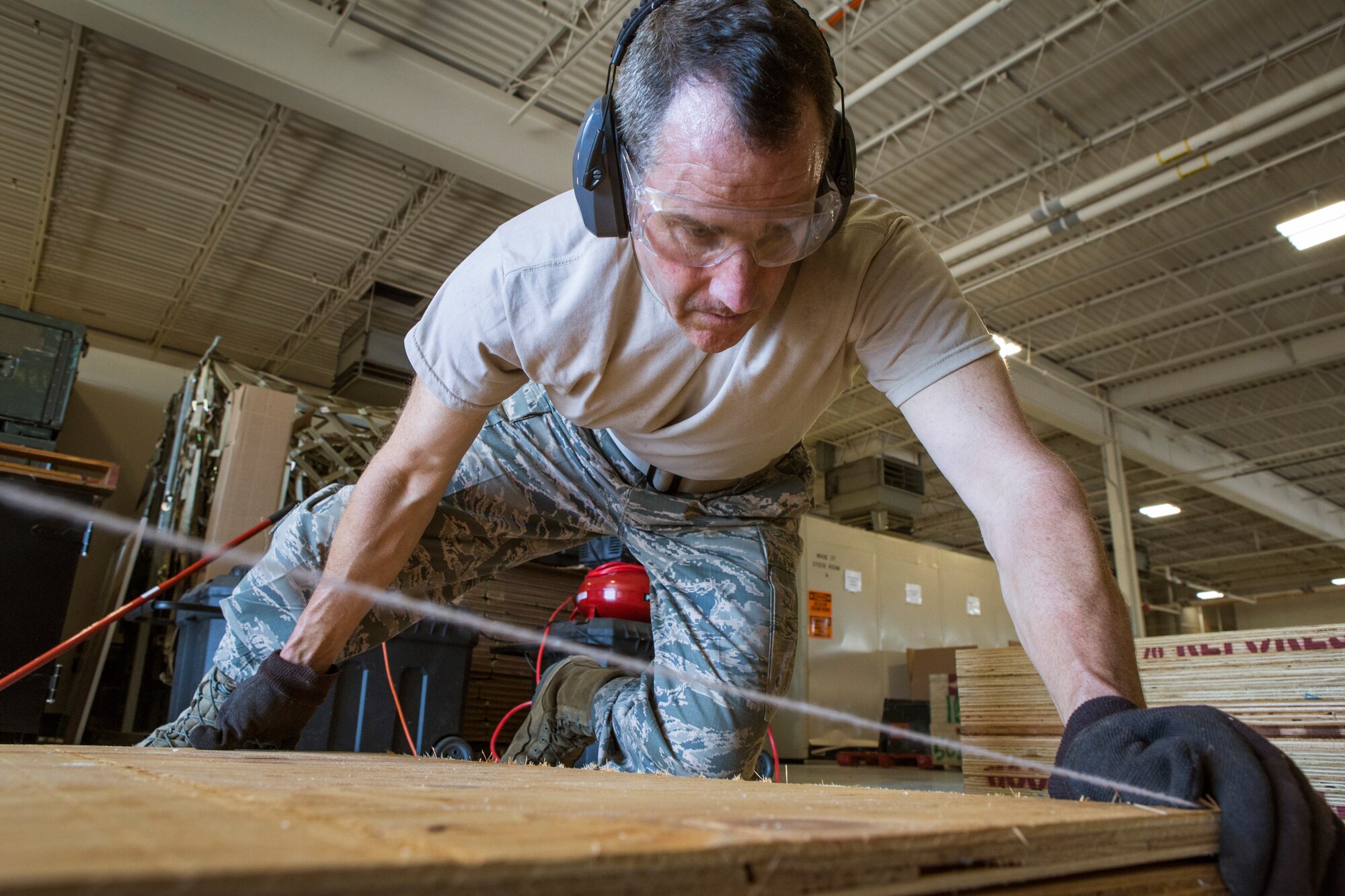 Master Sgt. Patrick J. Applegate, 108th Wing Traffic Management Office, New Jersey Air National Guard, positions a piece of plywood prior to nailing it for a shoring ramp that will be used to load a 1982 Mack 1250 GPM pumper fire truck on to a C-5 Galaxy at Joint Base McGuire-Dix-Lakehurst, N.J., June 30, 2016. The fire truck is being donated to a group of volunteer firefighters in Managua, Nicaragua through the Denton Program, which allows U.S. citizens and organizations to use space available on military cargo aircraft to transport humanitarian goods to countries in need. (U.S. Air National Guard photo by Master Sgt. Mark C. Olsen/Released)