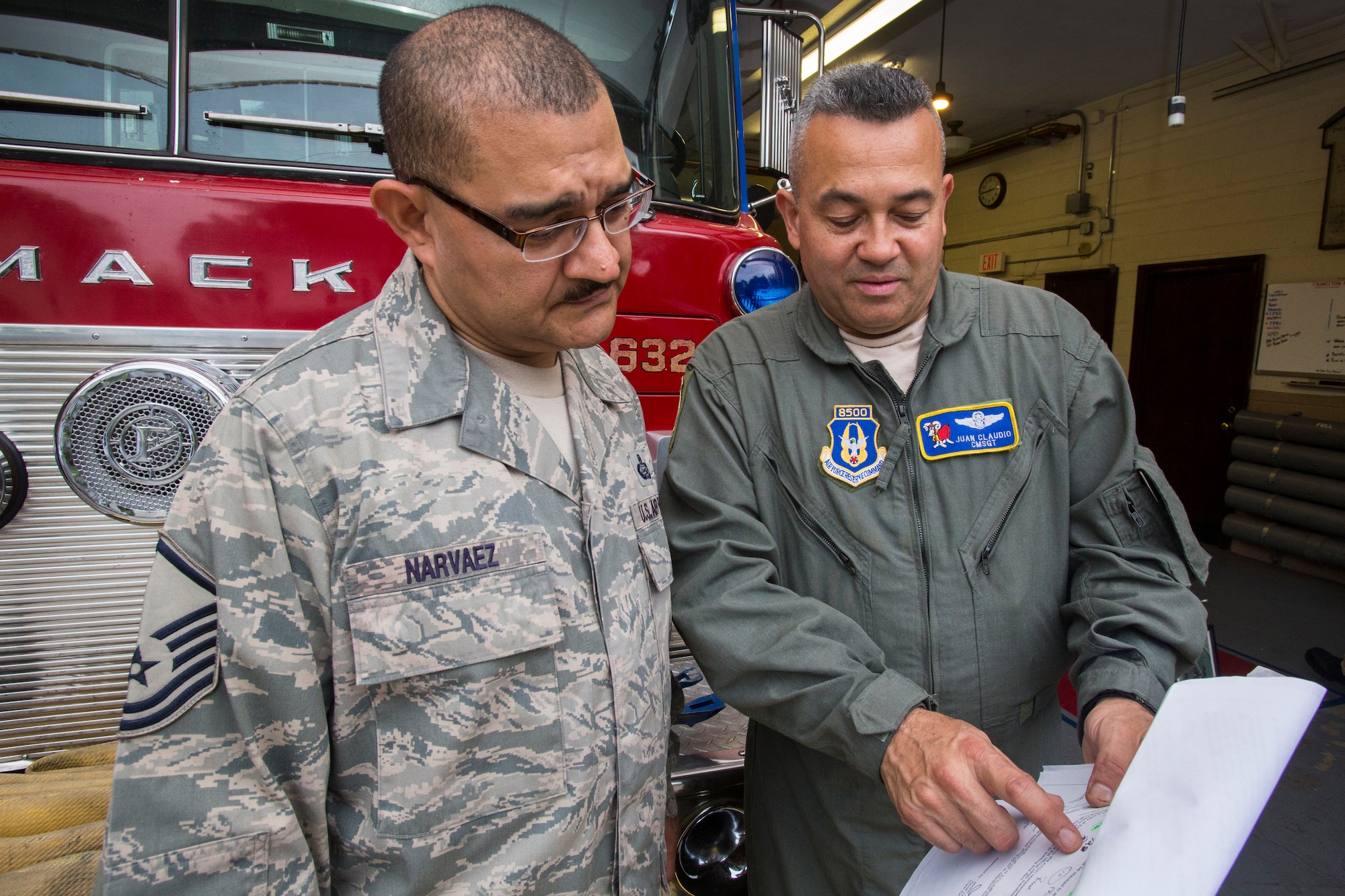 Master Sgt. Jorge A. Narvaez, left, 108th Wing Security Forces, New Jersey Air National Guard, listens as Chief Master Sgt. Juan Claudio, a loadmaster with the 514th Air Mobility Wing, Air Force Reserve, reviews the final list of measurements for a 1982 Mack 1250 GPM pumper fire truck at Mercer Engine No. 3 fire department in Princeton, N.J., July 13, 2016. Narvaez was instrumental in getting the truck donated to a group of volunteer firefighters in Managua, Nicaragua through the Denton Program, which allows U.S. citizens and organizations to use space available on military cargo aircraft to transport humanitarian goods to countries in need. (U.S. Air National Guard photo by Master Sgt. Mark C. Olsen/Released)